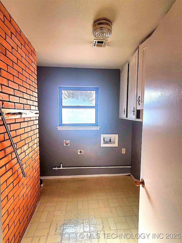 laundry room featuring cabinets, washer hookup, hookup for an electric dryer, and brick wall