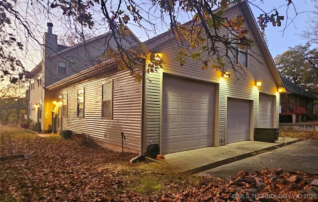 property exterior at dusk featuring a garage