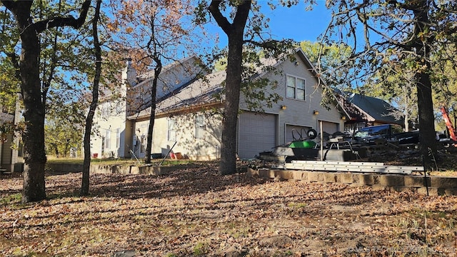 116568 S 4268th Rd, Checotah, OK 74426 - view of side of property featuring an attached garage and a chimney