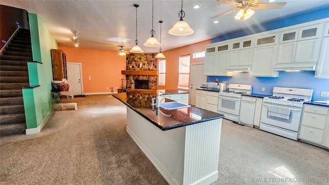 116568 S 4268th Rd, Checotah, OK 74426 - kitchen featuring a ceiling fan, white range with gas cooktop, a fireplace, light carpet, and recessed lighting