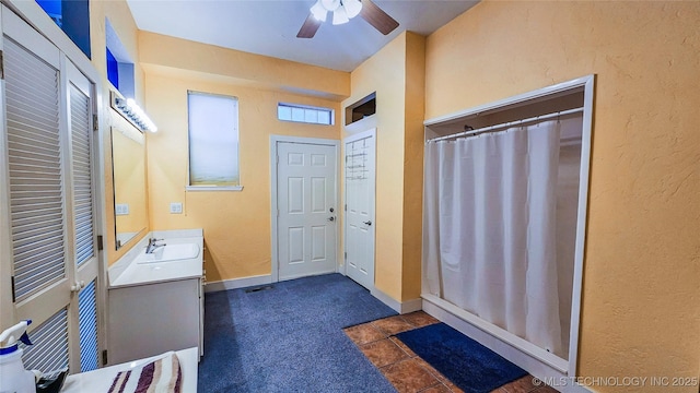 bathroom with a shower with shower curtain, ceiling fan, vanity, and tile patterned flooring