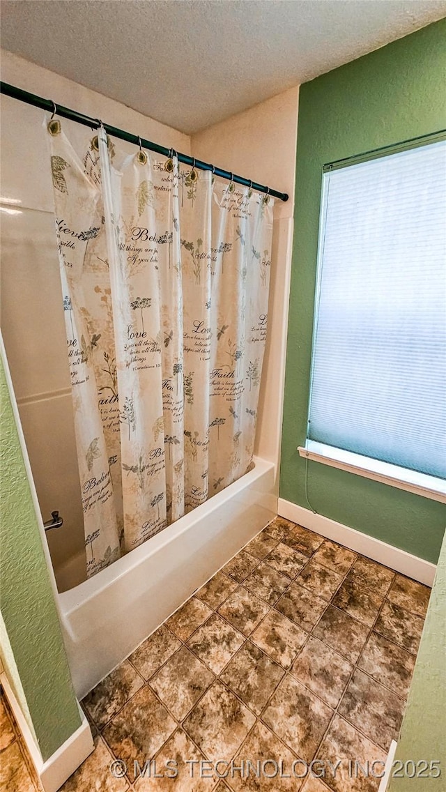 116568 S 4268th Rd, Checotah, OK 74426 - bathroom with a textured ceiling, shower / bath combo with shower curtain, a textured wall, and baseboards