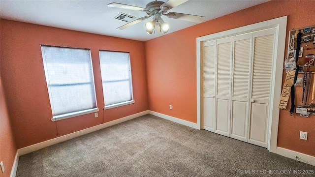 unfurnished bedroom featuring carpet floors, a closet, and ceiling fan