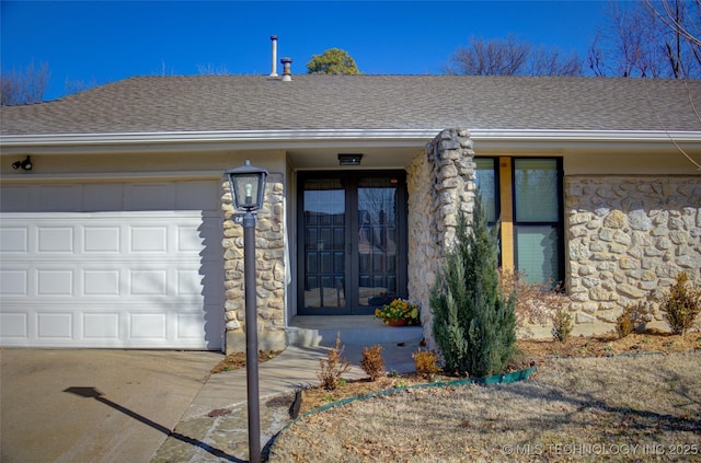 entrance to property featuring a garage and french doors