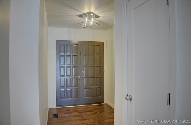 entrance foyer featuring dark wood-type flooring and a notable chandelier