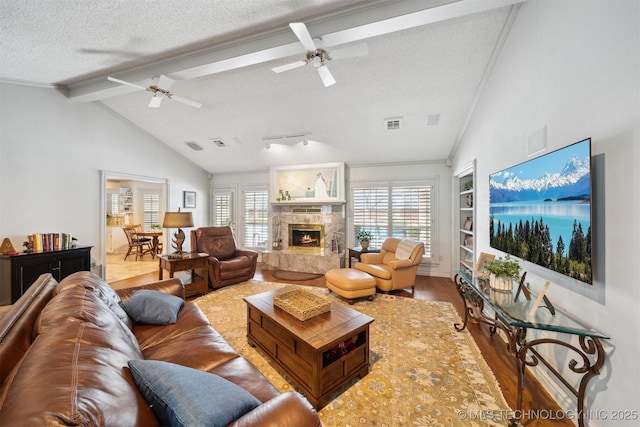 living room featuring hardwood / wood-style floors, vaulted ceiling with beams, ornamental molding, a high end fireplace, and a textured ceiling