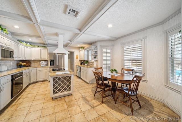 kitchen with appliances with stainless steel finishes, white cabinetry, a center island, coffered ceiling, and light stone countertops