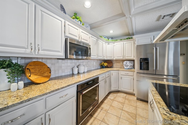 kitchen with white cabinetry, light stone counters, black appliances, and custom range hood