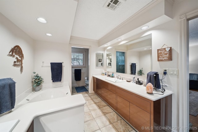 bathroom featuring a tub, tile patterned flooring, vanity, toilet, and crown molding