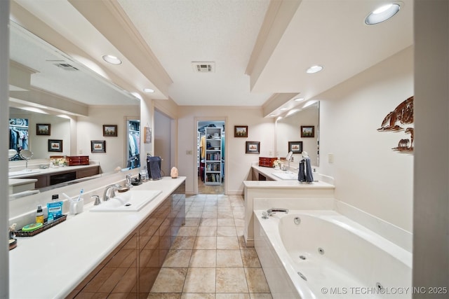 bathroom with vanity, tiled tub, crown molding, and tile patterned flooring