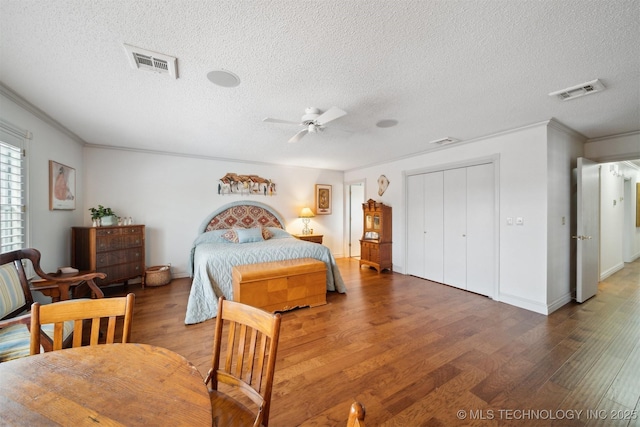 bedroom with ceiling fan, crown molding, a textured ceiling, and dark hardwood / wood-style flooring