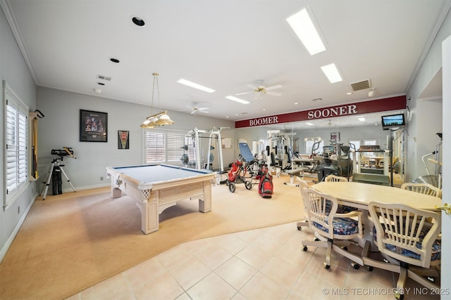 rec room with a wealth of natural light, light colored carpet, and crown molding