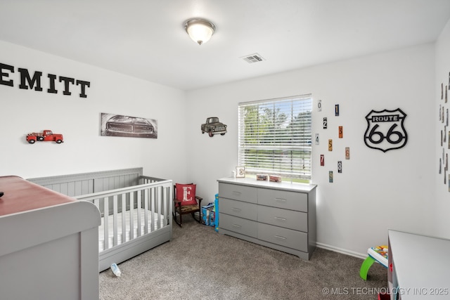 bedroom with a nursery area and carpet flooring