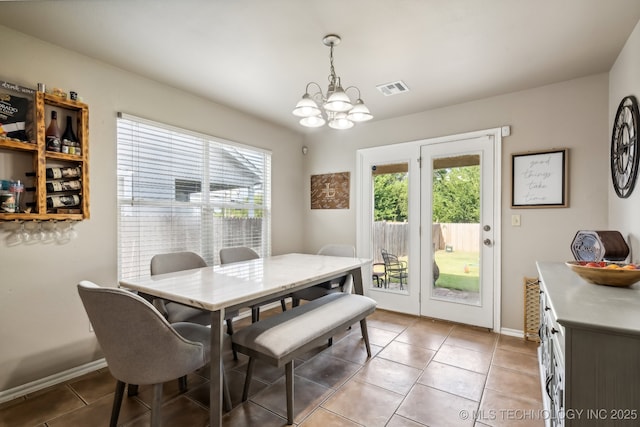 tiled dining area featuring a chandelier