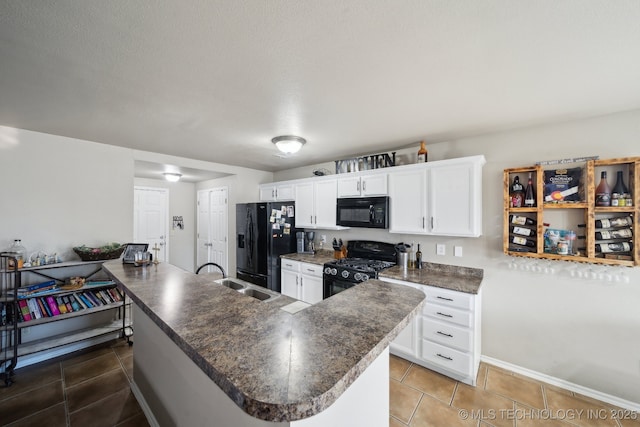 kitchen with tile patterned flooring, kitchen peninsula, white cabinets, and black appliances