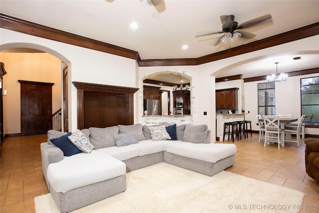 living room with crown molding and ceiling fan with notable chandelier