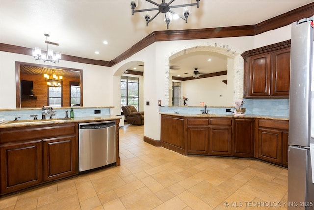 kitchen with sink, appliances with stainless steel finishes, backsplash, decorative light fixtures, and a chandelier