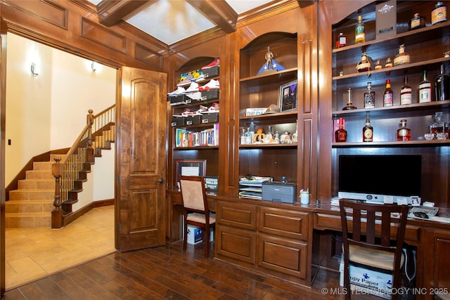 home office featuring built in shelves, built in desk, and dark hardwood / wood-style floors