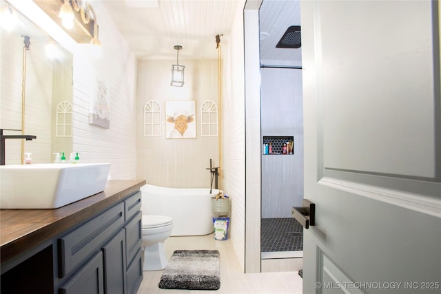 full bathroom featuring vanity, independent shower and bath, toilet, and tile walls