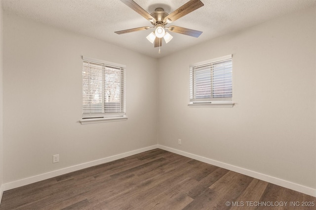 empty room featuring dark hardwood / wood-style flooring, a textured ceiling, and a healthy amount of sunlight