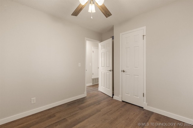 spare room with dark hardwood / wood-style flooring and ceiling fan