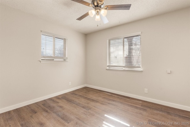 empty room with ceiling fan, a textured ceiling, a wealth of natural light, and wood-type flooring