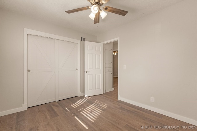 unfurnished bedroom featuring ceiling fan, hardwood / wood-style floors, and a textured ceiling