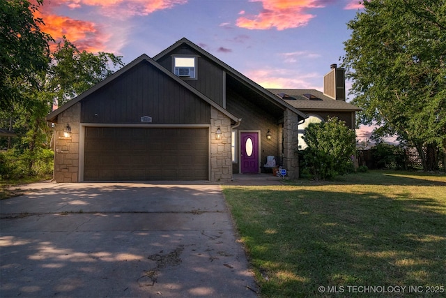 view of front of property featuring a garage and a lawn