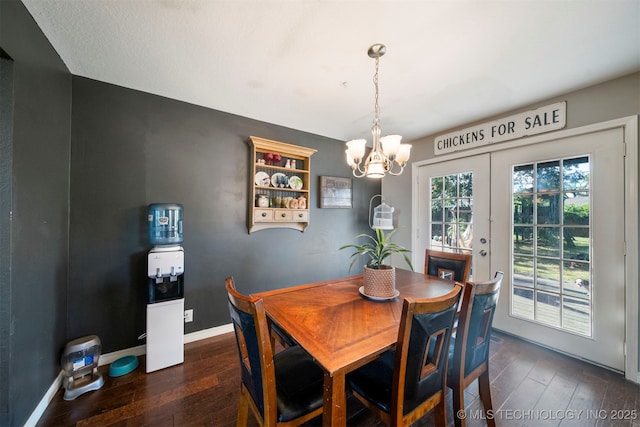 dining space featuring dark hardwood / wood-style flooring, french doors, and an inviting chandelier