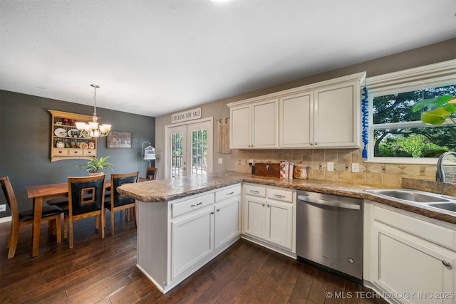 kitchen with sink, dark hardwood / wood-style floors, french doors, stainless steel dishwasher, and kitchen peninsula