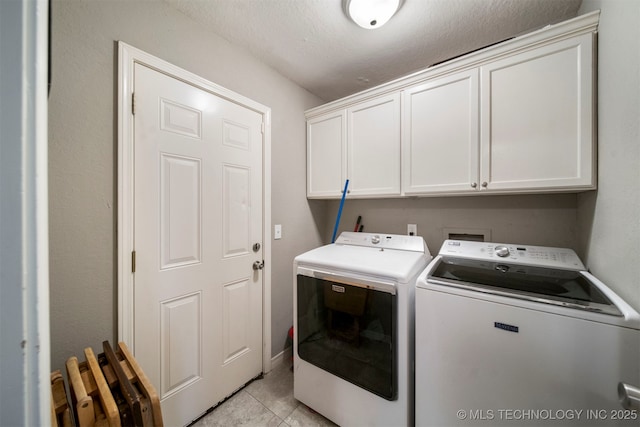 washroom featuring cabinets, independent washer and dryer, and light tile patterned flooring