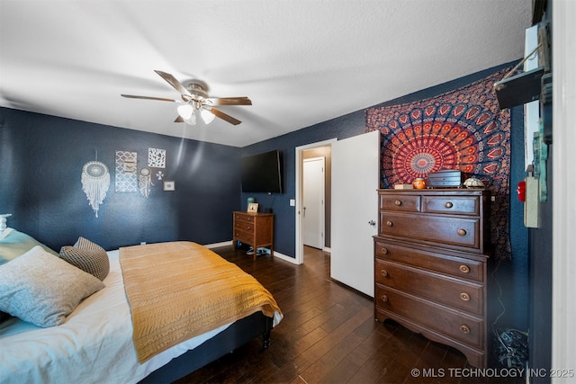 bedroom featuring dark wood-type flooring, a textured ceiling, and ceiling fan