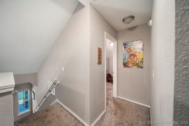 corridor with carpet and a textured ceiling