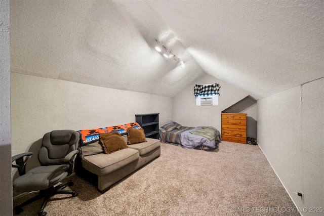 carpeted bedroom with lofted ceiling, rail lighting, and a textured ceiling