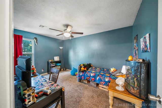 bedroom with ceiling fan, carpet flooring, and a textured ceiling