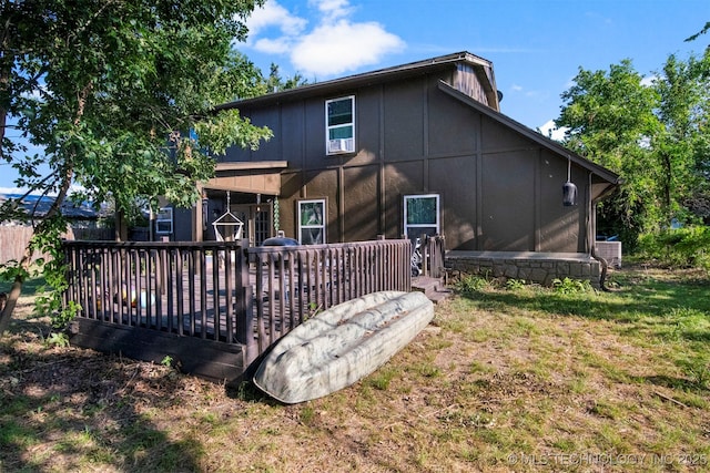 back of property with cooling unit, a wooden deck, and a lawn