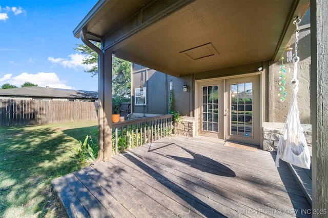 wooden deck with french doors and a yard