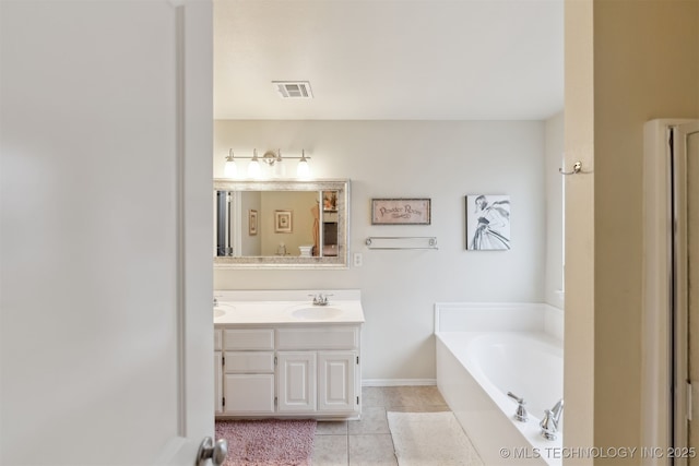 bathroom featuring tile patterned flooring, vanity, and a bath