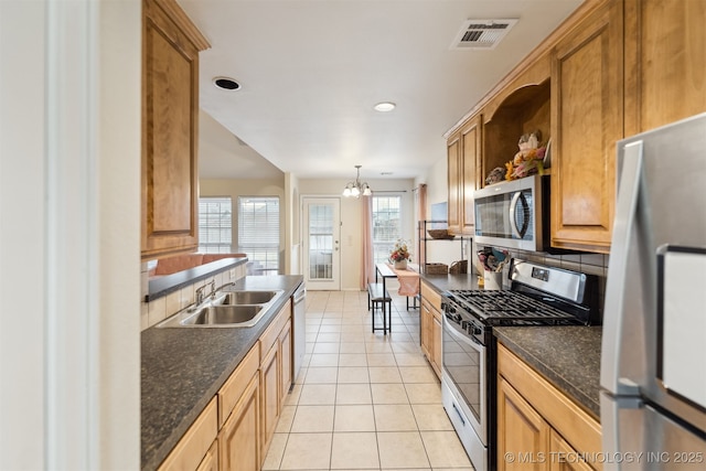 kitchen featuring sink, stainless steel appliances, tasteful backsplash, light tile patterned flooring, and decorative light fixtures