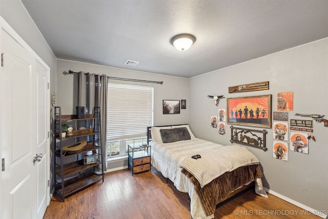 bedroom with dark wood-type flooring