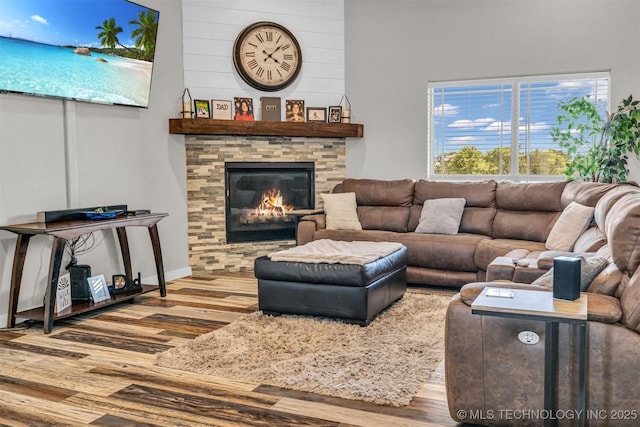 living room featuring a stone fireplace and hardwood / wood-style floors