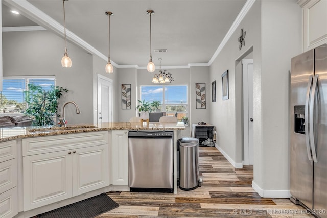 kitchen with sink, white cabinetry, crown molding, light stone counters, and appliances with stainless steel finishes