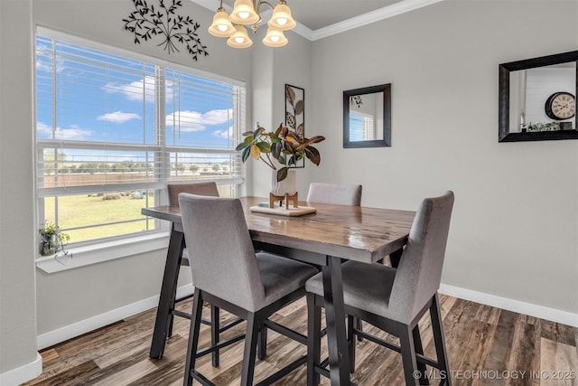 dining space featuring hardwood / wood-style flooring, ornamental molding, and a chandelier