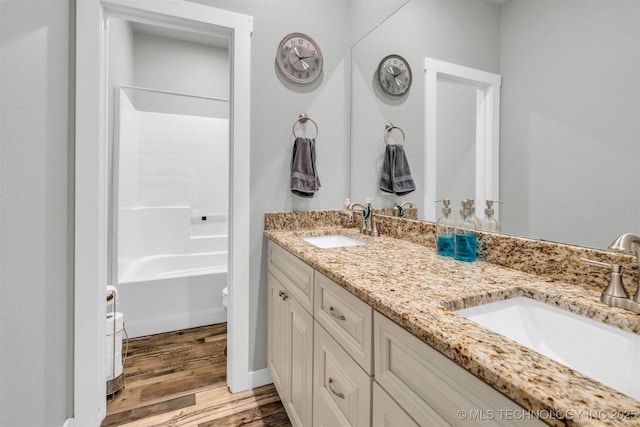 full bathroom featuring vanity, wood-type flooring, toilet, and washtub / shower combination