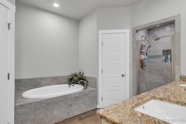 bathroom with vanity, shower with separate bathtub, and hardwood / wood-style floors