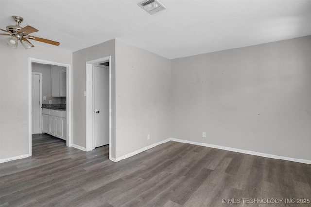 spare room featuring dark wood-type flooring and ceiling fan