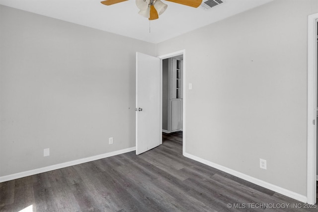 spare room featuring dark hardwood / wood-style flooring and ceiling fan