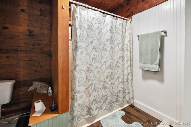 bathroom with hardwood / wood-style flooring, wooden walls, and toilet