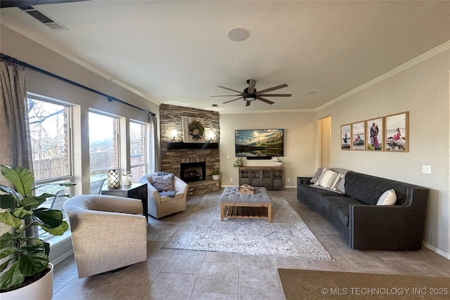 living room featuring ceiling fan, ornamental molding, a fireplace, and tile patterned flooring