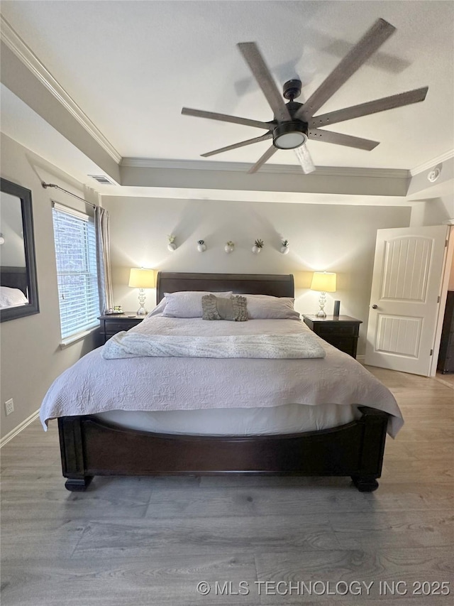 bedroom with crown molding, ceiling fan, and hardwood / wood-style flooring